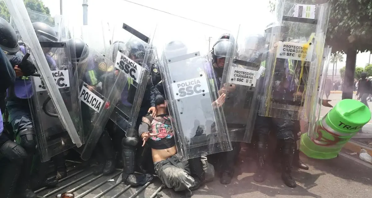 Chocan encapuchados con granaderos en la entrada del estadio Azteca